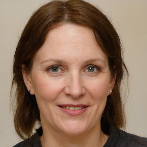 Joyful white adult female with medium  brown hair and brown eyes