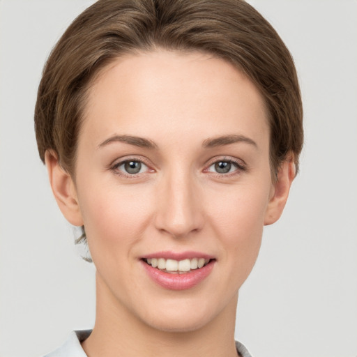 Joyful white young-adult female with short  brown hair and grey eyes