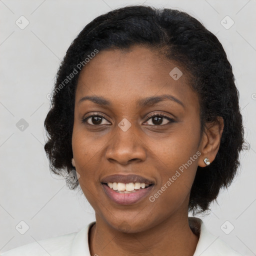 Joyful black young-adult female with long  black hair and brown eyes