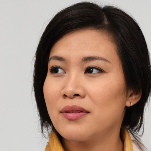 Joyful asian young-adult female with medium  brown hair and brown eyes