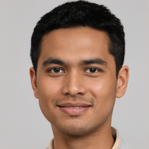 Joyful latino young-adult male with short  black hair and brown eyes