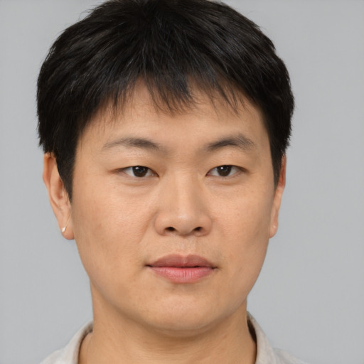 Joyful asian young-adult male with short  brown hair and brown eyes