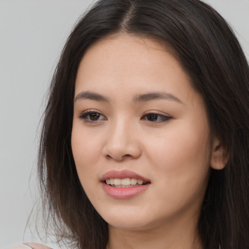 Joyful asian young-adult female with long  brown hair and brown eyes