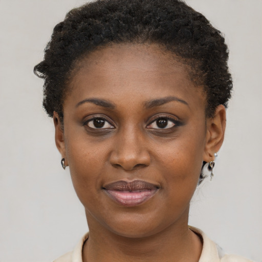 Joyful black young-adult female with short  brown hair and brown eyes