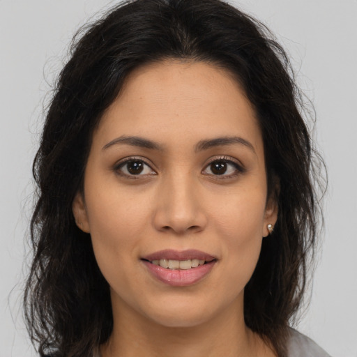 Joyful latino young-adult female with medium  brown hair and brown eyes