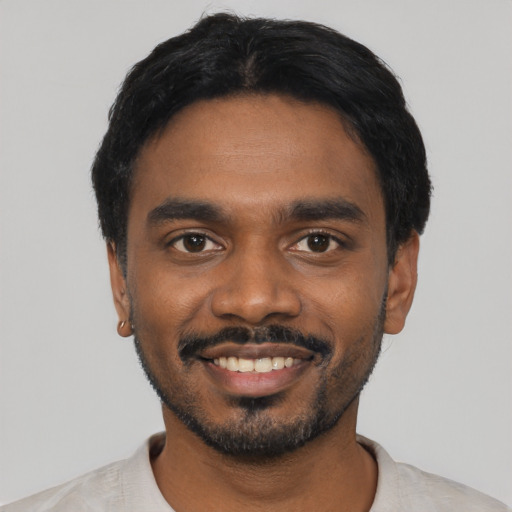 Joyful black young-adult male with short  black hair and brown eyes