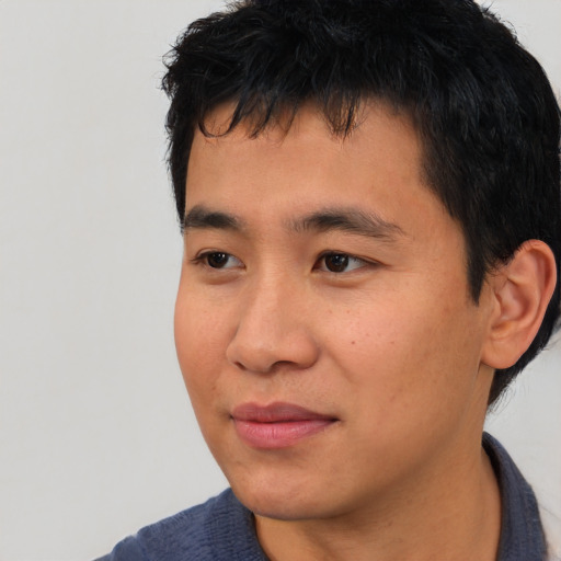 Joyful asian young-adult male with short  black hair and brown eyes