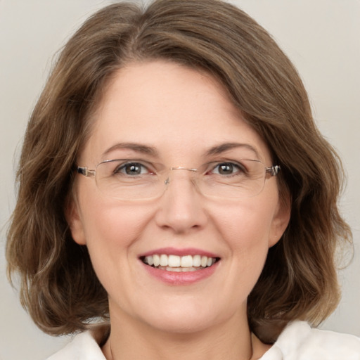 Joyful white adult female with medium  brown hair and green eyes