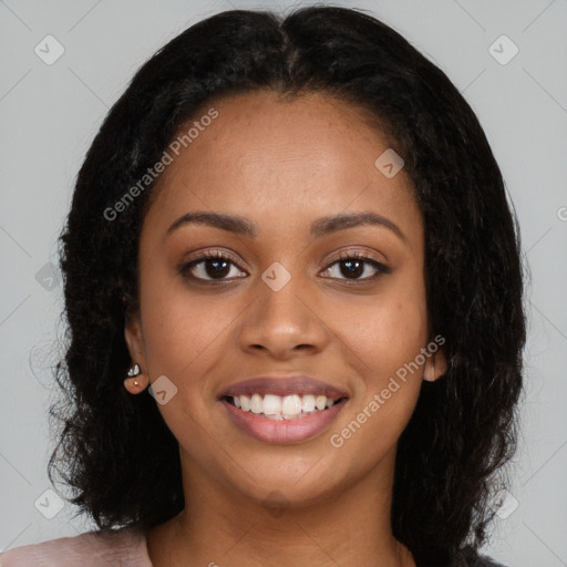 Joyful black young-adult female with long  black hair and brown eyes