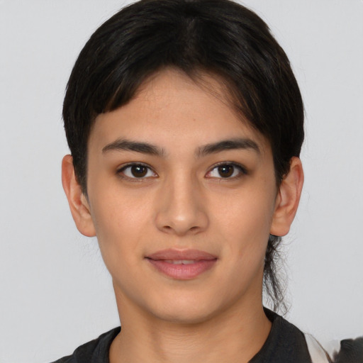 Joyful latino young-adult female with short  black hair and brown eyes