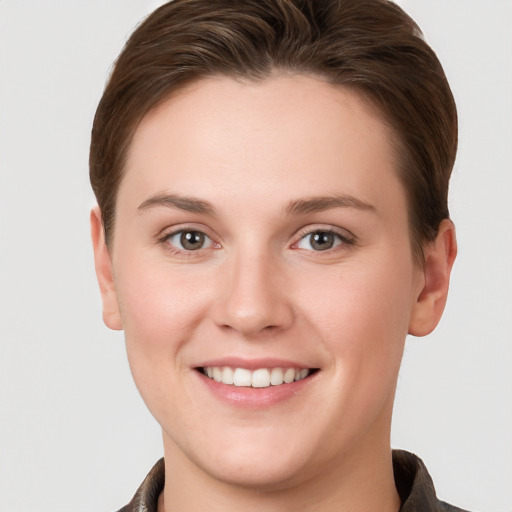 Joyful white young-adult female with short  brown hair and grey eyes