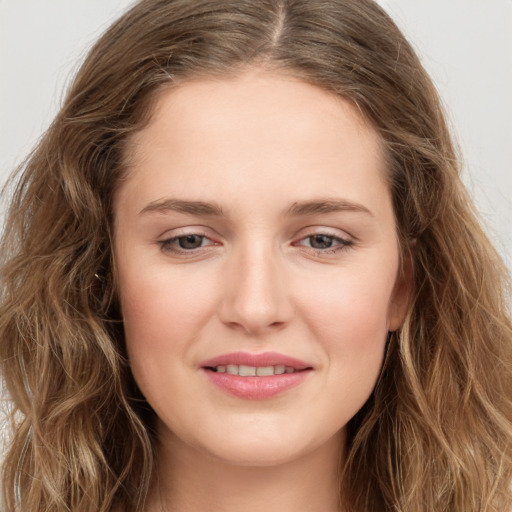 Joyful white young-adult female with long  brown hair and green eyes