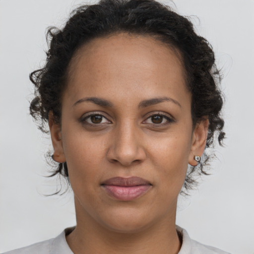 Joyful latino young-adult female with short  brown hair and brown eyes