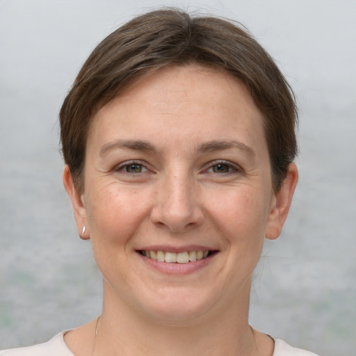 Joyful white adult female with short  brown hair and grey eyes