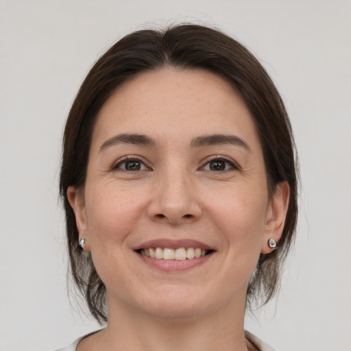 Joyful white young-adult female with medium  brown hair and brown eyes