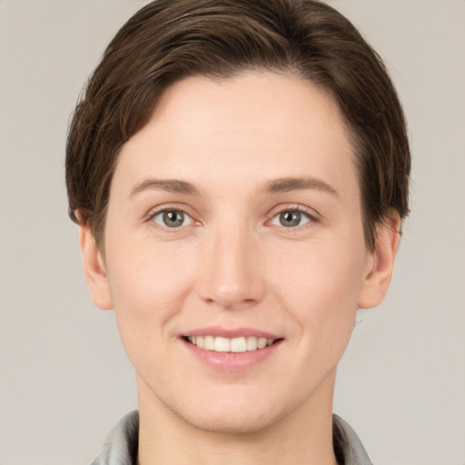 Joyful white young-adult female with short  brown hair and grey eyes