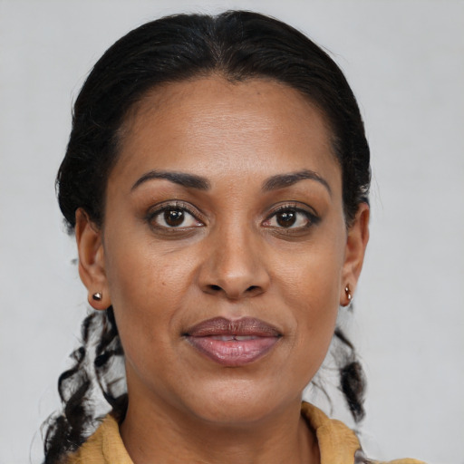 Joyful black adult female with medium  brown hair and brown eyes