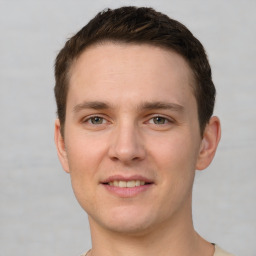 Joyful white young-adult male with short  brown hair and grey eyes