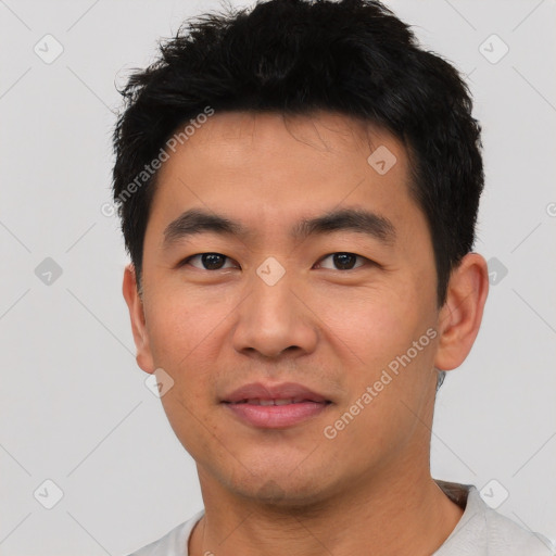 Joyful asian young-adult male with short  black hair and brown eyes