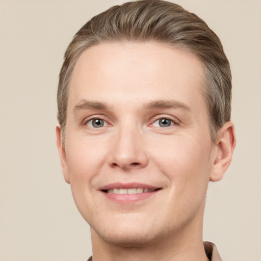 Joyful white young-adult male with short  brown hair and grey eyes