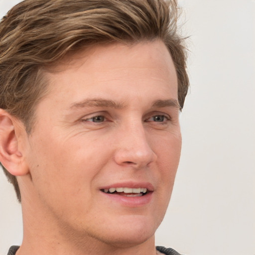 Joyful white young-adult male with short  brown hair and grey eyes