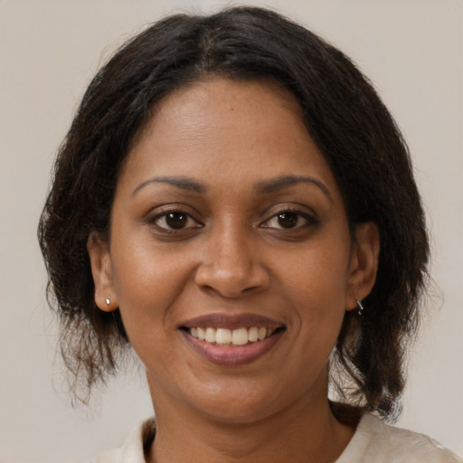 Joyful black adult female with medium  brown hair and brown eyes