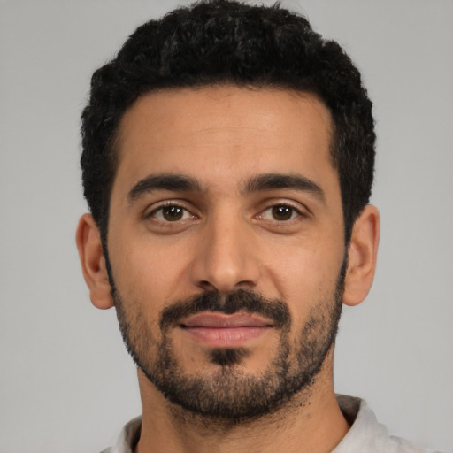 Joyful latino young-adult male with short  black hair and brown eyes