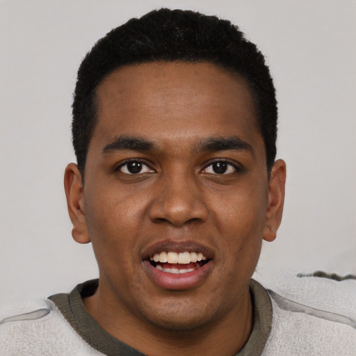 Joyful black young-adult male with short  black hair and brown eyes