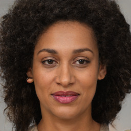 Joyful black adult female with medium  brown hair and brown eyes