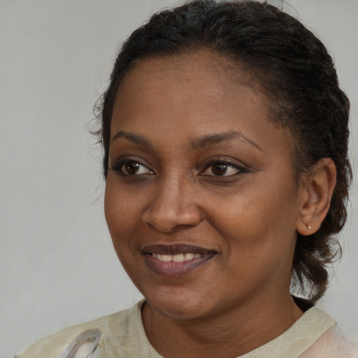 Joyful black young-adult female with short  brown hair and brown eyes