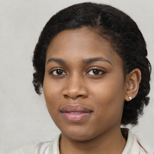 Joyful black young-adult female with medium  black hair and brown eyes