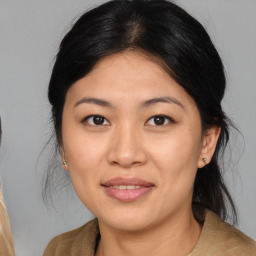 Joyful asian young-adult female with medium  brown hair and brown eyes