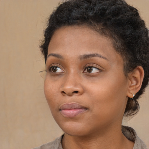 Joyful black young-adult female with medium  brown hair and brown eyes