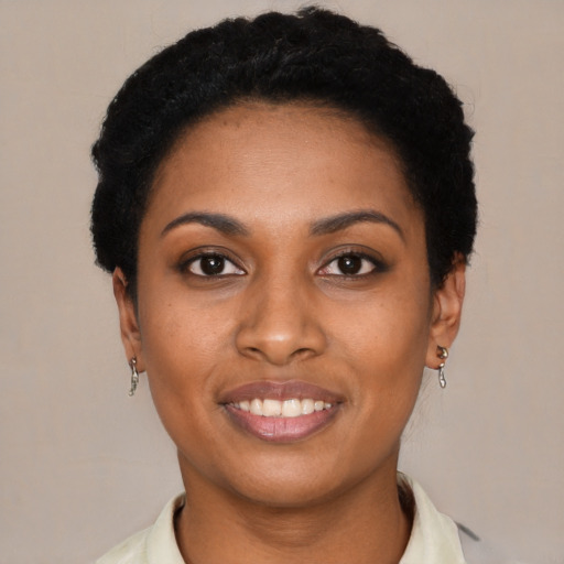Joyful black young-adult female with short  black hair and brown eyes
