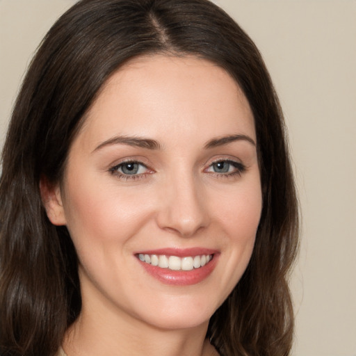 Joyful white young-adult female with long  brown hair and brown eyes