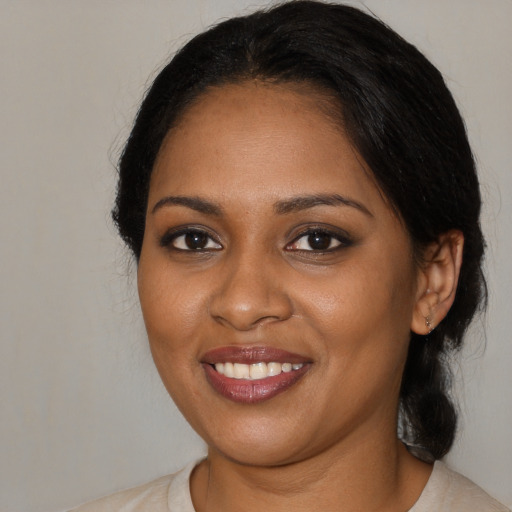 Joyful black young-adult female with medium  black hair and brown eyes