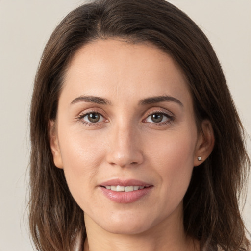 Joyful white young-adult female with long  brown hair and grey eyes