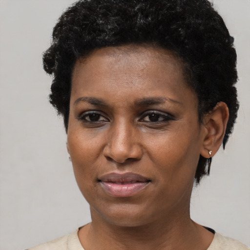 Joyful black young-adult female with short  black hair and brown eyes