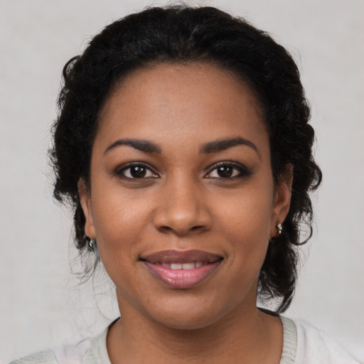 Joyful black young-adult female with medium  black hair and brown eyes