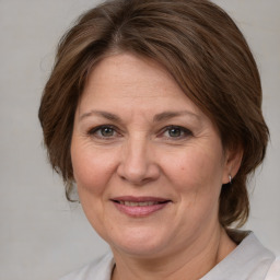 Joyful white adult female with medium  brown hair and brown eyes