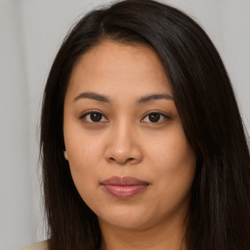 Joyful latino young-adult female with long  brown hair and brown eyes