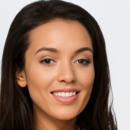 Joyful latino young-adult female with long  brown hair and brown eyes