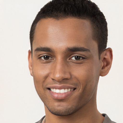 Joyful black young-adult male with short  brown hair and brown eyes