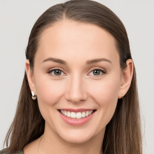 Joyful white young-adult female with long  brown hair and grey eyes