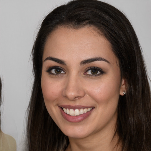 Joyful white young-adult female with long  brown hair and brown eyes