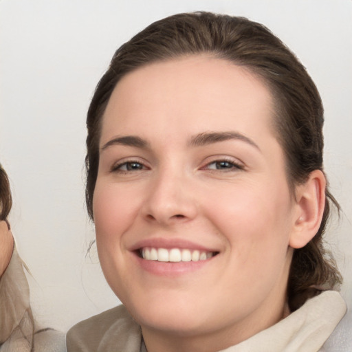 Joyful white young-adult female with medium  brown hair and grey eyes