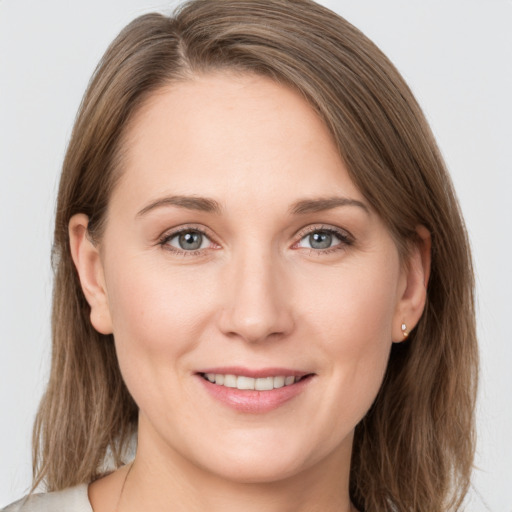 Joyful white young-adult female with medium  brown hair and grey eyes