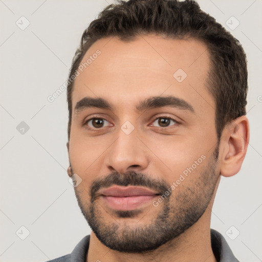 Joyful white young-adult male with short  black hair and brown eyes