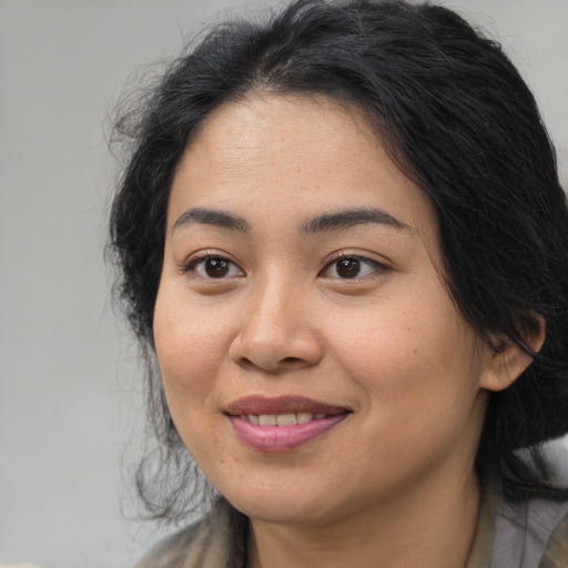 Joyful asian young-adult female with long  brown hair and brown eyes
