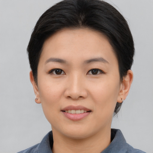 Joyful asian young-adult female with short  black hair and brown eyes